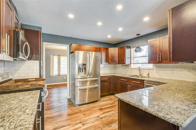 55 Willow Ct, Lake Jackson, TX 77566 - kitchen featuring appliances with stainless steel finishes, a sink, light wood finished floors, light stone countertops, and recessed lighting