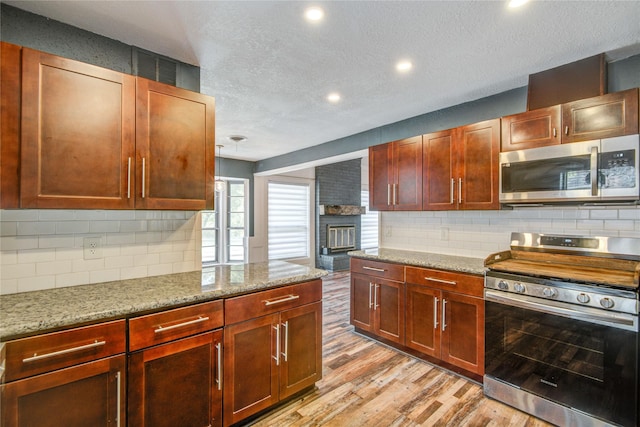 55 Willow Ct, Lake Jackson, TX 77566 - kitchen featuring appliances with stainless steel finishes, a textured ceiling, tasteful backsplash, light wood-style flooring, and recessed lighting