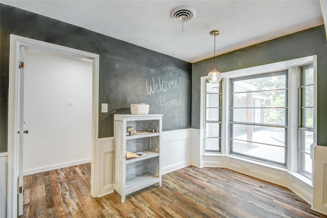 55 Willow Ct, Lake Jackson, TX 77566 - unfurnished dining area with wood finished floors, a textured ceiling, and wainscoting