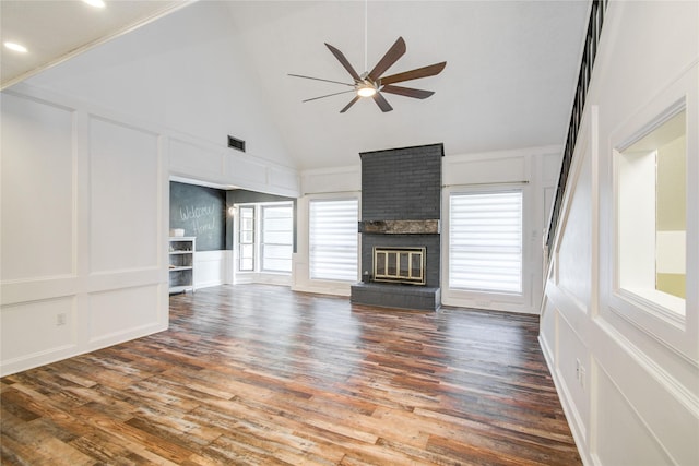 55 Willow Ct, Lake Jackson, TX 77566 - unfurnished living room with a decorative wall, ceiling fan, high vaulted ceiling, a brick fireplace, and wood finished floors