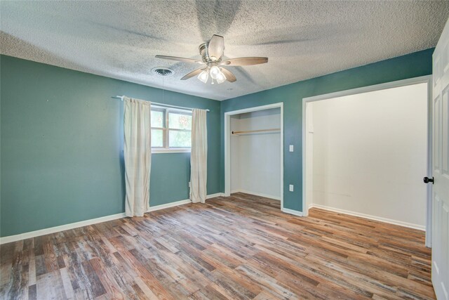 55 Willow Ct, Lake Jackson, TX 77566 - unfurnished bedroom featuring wood finished floors, a closet, baseboards, a textured ceiling, and a ceiling fan
