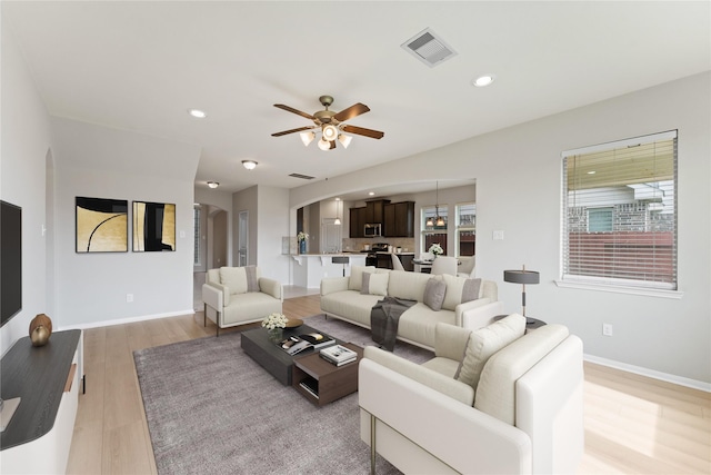 14818 Autumn Long Trl, Humble, TX 77396 - living area featuring arched walkways, a ceiling fan, light wood-type flooring, recessed lighting, and baseboards