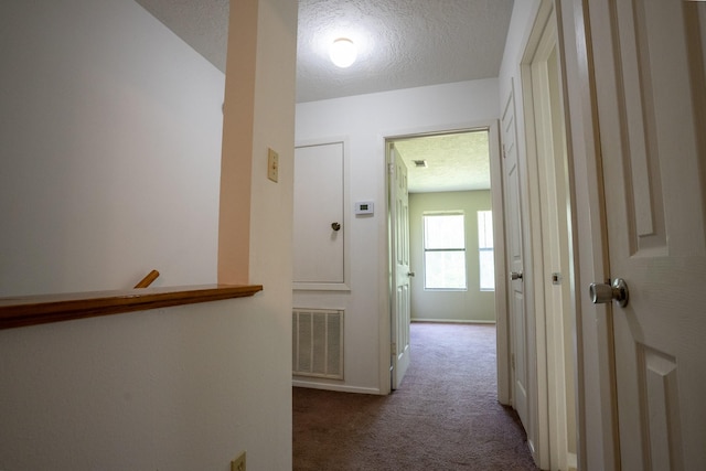 2521 Crosstimbers St Unit G3, Huntsville, TX 77320 - hallway featuring carpet floors, a textured ceiling, and baseboards