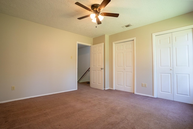 2521 Crosstimbers St Unit G3, Huntsville, TX 77320 - unfurnished bedroom with carpet floors, multiple closets, a textured ceiling, baseboards, and ceiling fan