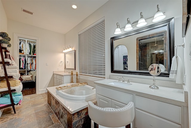 105 Checkerbloom Ct, Montgomery, TX 77316 - bathroom with stone tile floors, a tile shower, a bath, two vanities, and recessed lighting