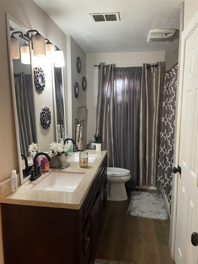 4015 42nd St, Port Arthur, TX 77642 - full bathroom featuring wood finished floors, vanity, toilet, and a textured ceiling