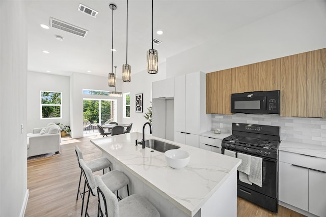 1216 E 34th St Unit B, Houston, TX 77022 - kitchen with black appliances, a sink, tasteful backsplash, modern cabinets, and recessed lighting