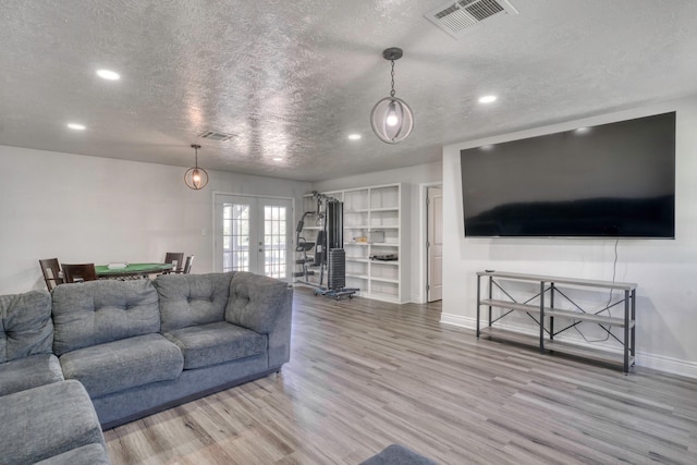 3508 Dick Barnes Loop, Bedias, TX 77831 - living room with a textured ceiling, recessed lighting, french doors, light wood-style flooring, and baseboards