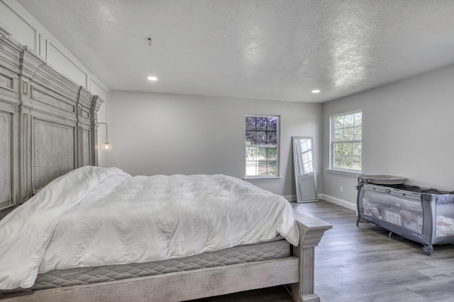 3508 Dick Barnes Loop, Bedias, TX 77831 - bedroom with wood finished floors, recessed lighting, a textured ceiling, and baseboards