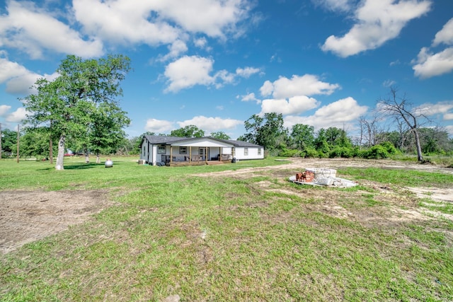 3508 Dick Barnes Loop, Bedias, TX 77831 - view of grassy yard featuring a porch and an outdoor fire pit