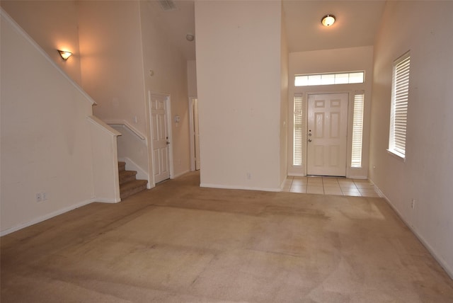 21031 Noelle Ct, Humble, TX 77338 - entrance foyer featuring a towering ceiling, light carpet, stairs, baseboards, and light tile patterned floors