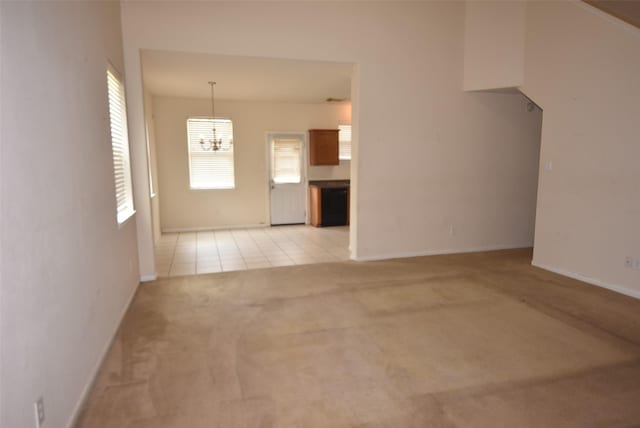 21031 Noelle Ct, Humble, TX 77338 - unfurnished living room featuring a chandelier, light colored carpet, baseboards, and light tile patterned floors