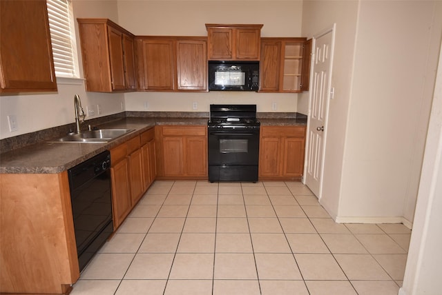 21031 Noelle Ct, Humble, TX 77338 - kitchen with black appliances, a sink, dark countertops, light tile patterned floors, and brown cabinets