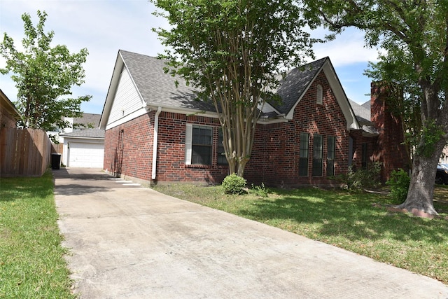 view of front of property featuring brick siding, a shingled roof, driveway, and a detached garage
