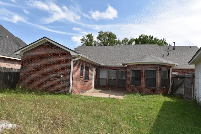 rear view of house featuring brick siding, a patio area, and roof with shingles
