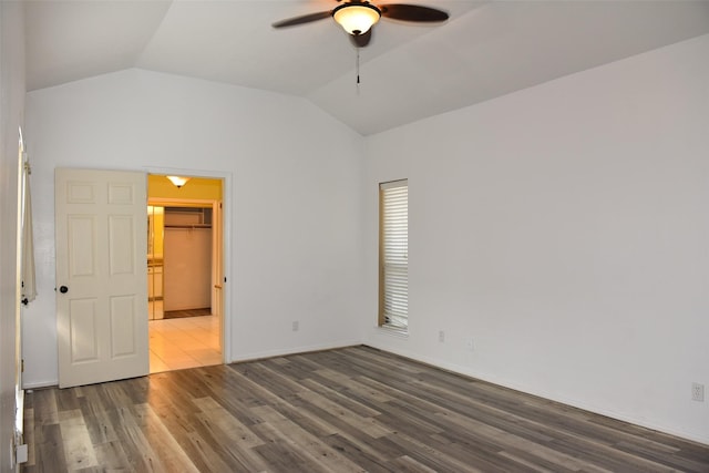 unfurnished bedroom featuring vaulted ceiling, wood finished floors, baseboards, and ceiling fan