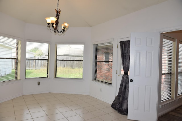 unfurnished dining area with a chandelier, light tile patterned flooring, and baseboards
