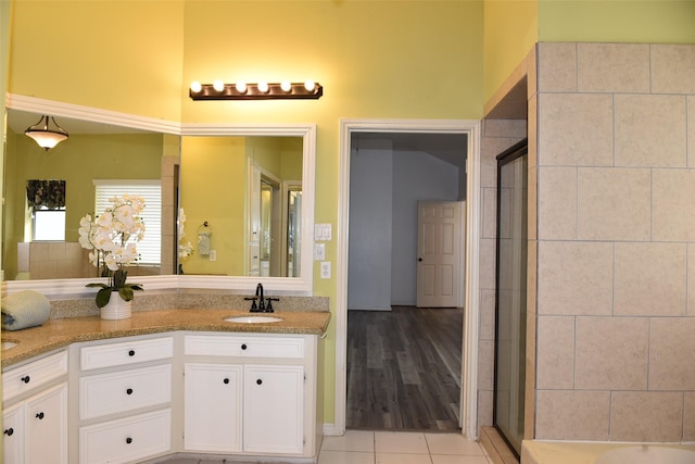 full bath featuring tile patterned flooring, tiled shower, vanity, and a bath