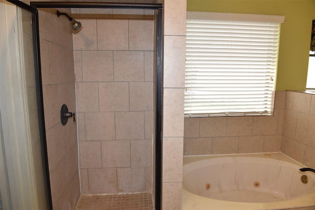 bathroom with a shower stall and a jetted tub