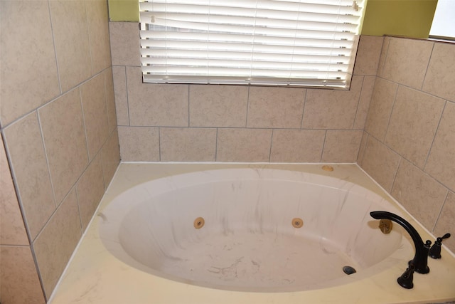 bathroom featuring a jetted tub and healthy amount of natural light
