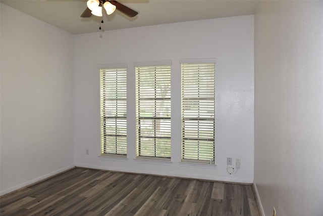 spare room featuring a ceiling fan, dark wood finished floors, and plenty of natural light