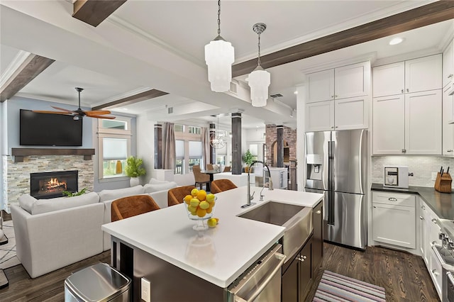 1202 Archer St, Houston, TX 77009 - kitchen featuring appliances with stainless steel finishes, a sink, a ceiling fan, dark wood finished floors, and beamed ceiling