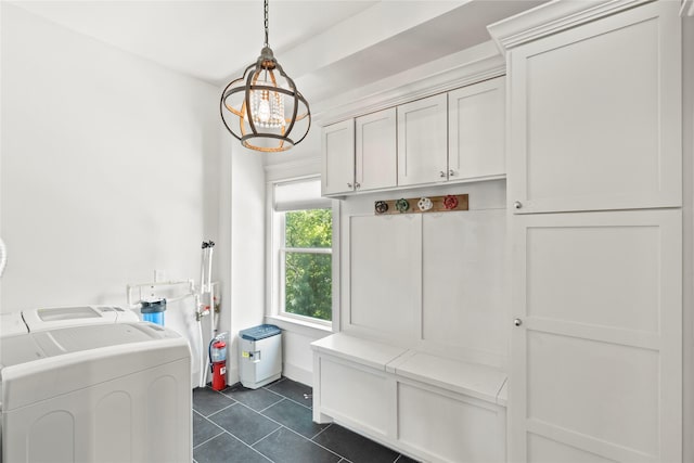 1202 Archer St, Houston, TX 77009 - laundry room featuring washer and clothes dryer, a chandelier, dark tile patterned flooring, and cabinet space