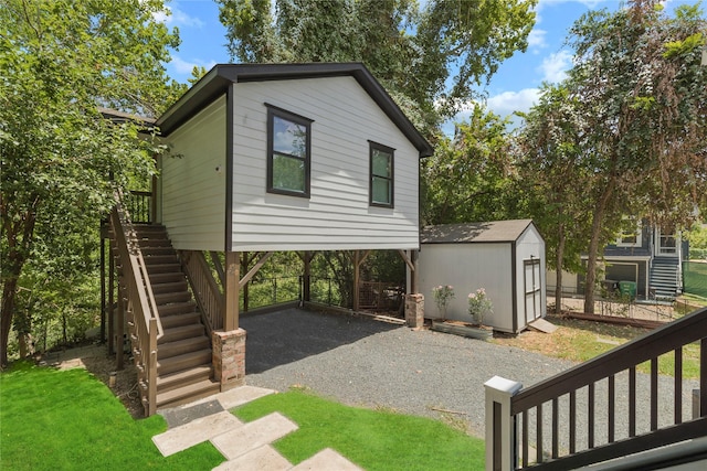 1202 Archer St, Houston, TX 77009 - view of side of property featuring stairway, gravel driveway, and a carport