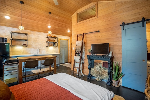 1202 Archer St, Houston, TX 77009 - bedroom featuring a barn door, a sink, wooden ceiling, wood walls, and freestanding refrigerator