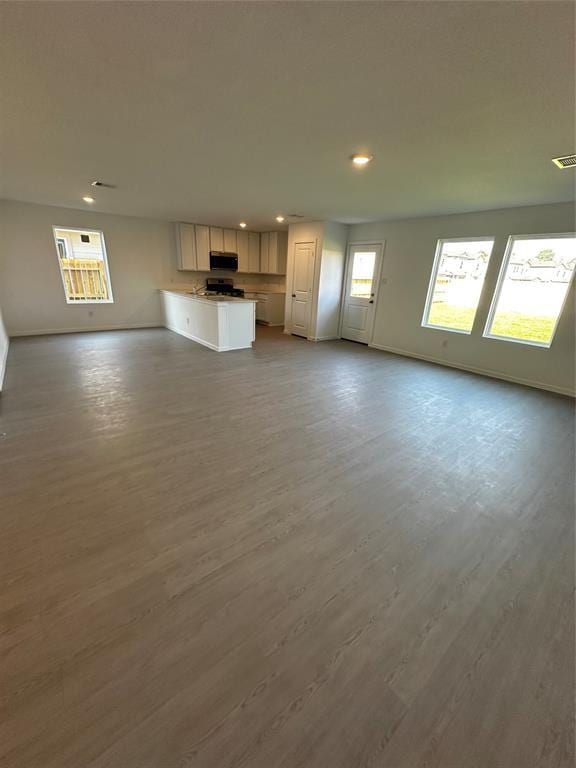 12414 Lady Slipper Rd, Houston, TX 77038 - unfurnished living room featuring recessed lighting, wood finished floors, and baseboards