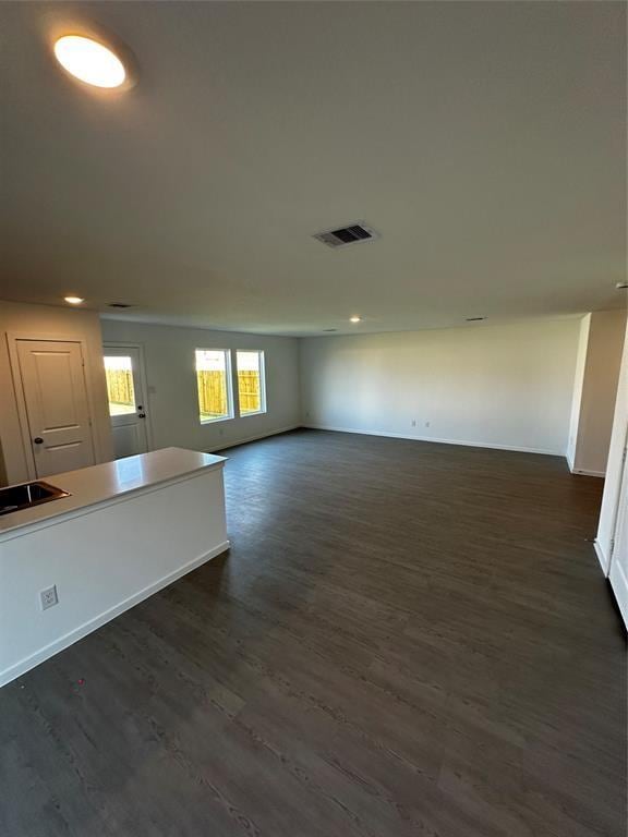 12414 Lady Slipper Rd, Houston, TX 77038 - unfurnished living room with dark wood-style flooring, recessed lighting, and baseboards