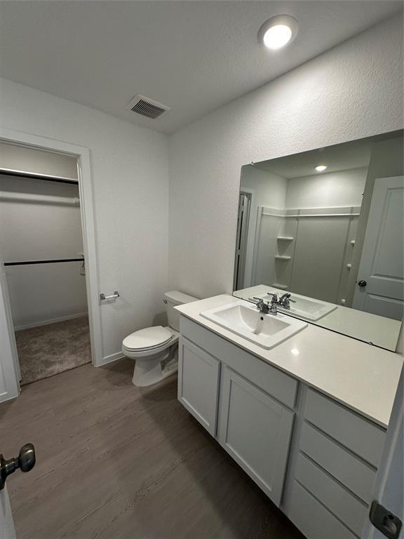 12414 Lady Slipper Rd, Houston, TX 77038 - bathroom featuring wood finished floors, toilet, vanity, a shower, and baseboards