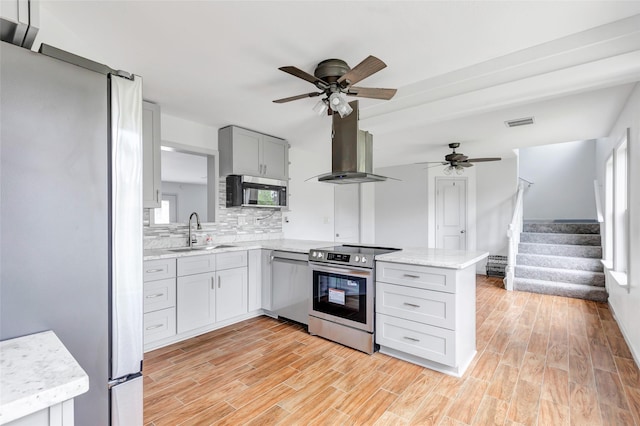 18586 Summer Hills Blvd, Porter, TX 77365 - kitchen featuring stainless steel appliances, island exhaust hood, a ceiling fan, and a peninsula