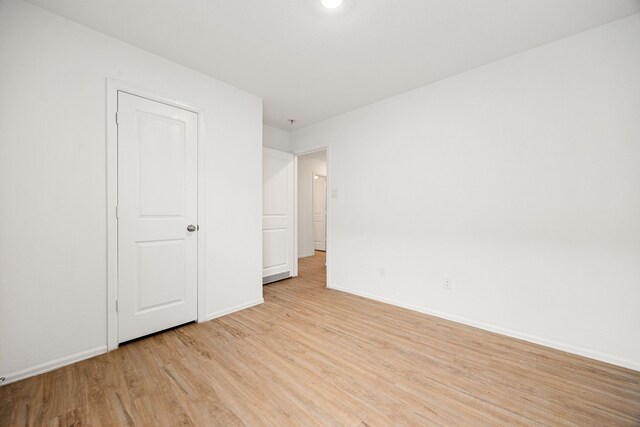 4347 Palmetto Grove Ln, Baytown, TX 77521 - unfurnished bedroom with light wood-style floors and baseboards
