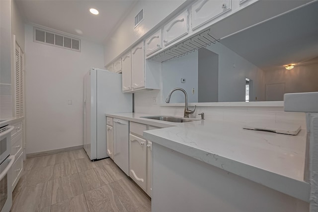 1881 Bering Dr Unit 27, Houston, TX 77057 - kitchen featuring a sink, white cabinetry, white appliances, light stone counters, and recessed lighting
