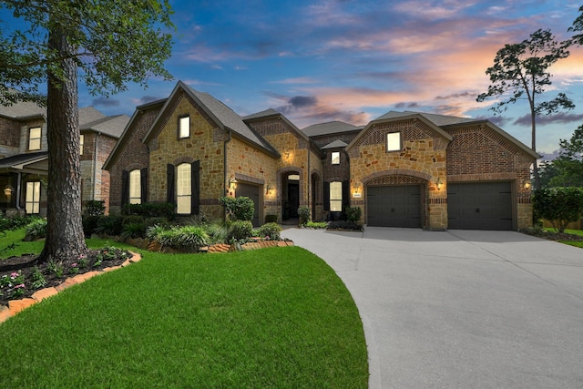 18910 Winding Atwood Ln, Tomball, TX 77377 - french country style house featuring a garage, a lawn, stone siding, and driveway