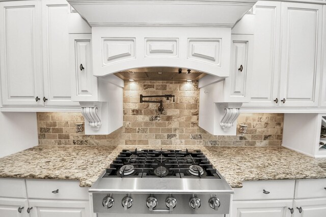18910 Winding Atwood Ln, Tomball, TX 77377 - kitchen with stainless steel gas cooktop, decorative backsplash, white cabinetry, and light stone countertops