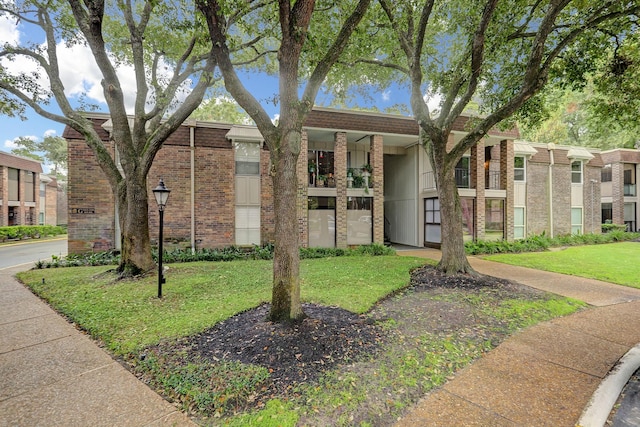 7575 Katy Fwy Unit 17, Houston, TX 77024 - view of front of property featuring brick siding and a front yard