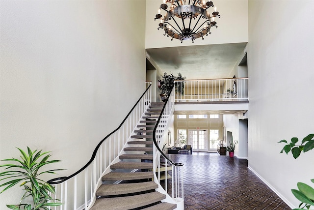 7575 Katy Fwy Unit 17, Houston, TX 77024 - stairs with a high ceiling, baseboards, a chandelier, and brick flooring