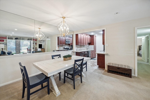 7575 Katy Fwy Unit 17, Houston, TX 77024 - dining room with a chandelier, light carpet, baseboards, and recessed lighting