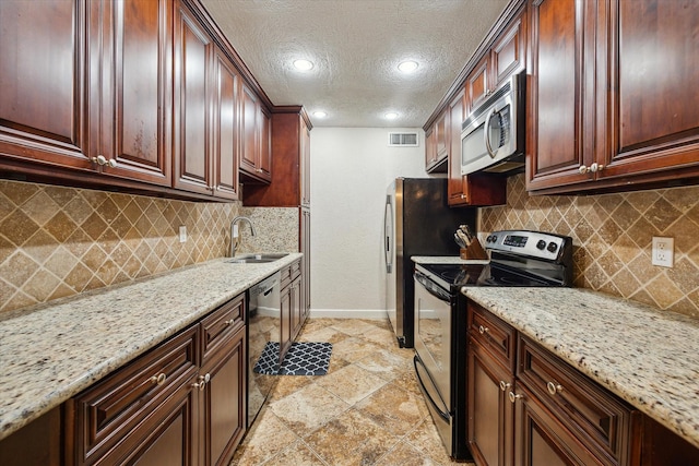 7575 Katy Fwy Unit 17, Houston, TX 77024 - kitchen featuring stainless steel appliances, baseboards, a sink, light stone counters, and tasteful backsplash