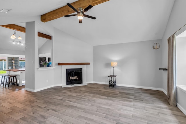 9802 Pale Star Dr, Houston, TX 77064 - unfurnished living room featuring beamed ceiling, a ceiling fan, a fireplace with raised hearth, wood finished floors, and baseboards