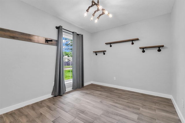9802 Pale Star Dr, Houston, TX 77064 - unfurnished room featuring wood finished floors, a chandelier, and baseboards