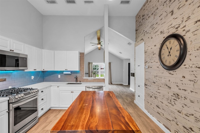 9802 Pale Star Dr, Houston, TX 77064 - kitchen featuring stainless steel appliances, light wood finished floors, a sink, a ceiling fan, and an accent wall