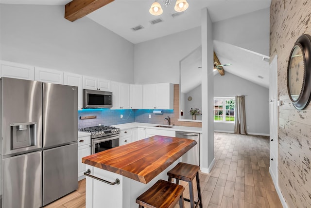 9802 Pale Star Dr, Houston, TX 77064 - kitchen featuring stainless steel appliances, light wood-style floors, a sink, tasteful backsplash, and white cabinetry