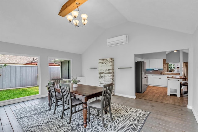 9802 Pale Star Dr, Houston, TX 77064 - dining area featuring a wall mounted air conditioner, light wood-style flooring, a chandelier, high vaulted ceiling, and baseboards