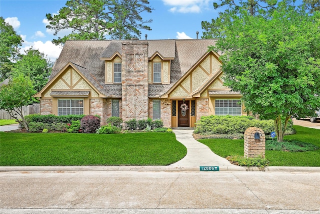 12806 Ivyforest Dr, Cypress, TX 77429 - tudor home with a front yard, a shingled roof, and brick siding