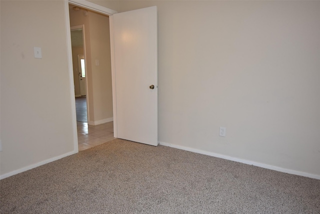 8115 Swan Meadow Ln, Humble, TX 77338 - empty room with light colored carpet, baseboards, and light tile patterned floors