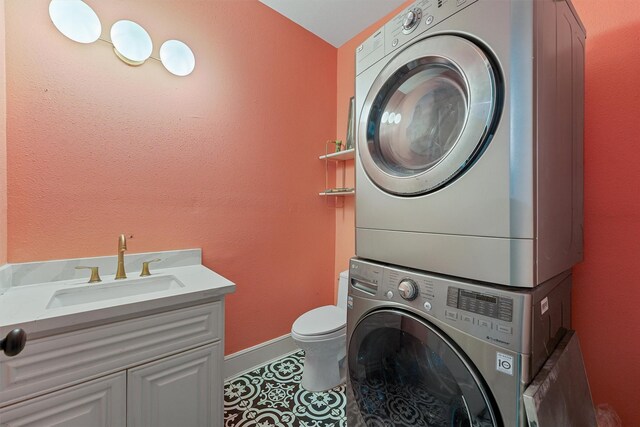2719 Alabama St, Houston, TX 77004 - washroom with estacked washer and dryer, tile patterned flooring, and baseboards