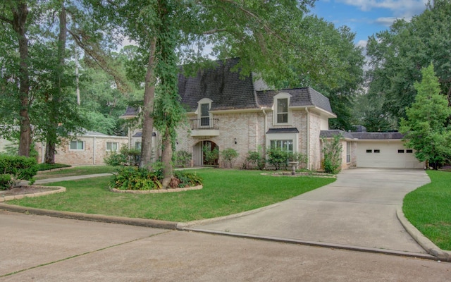 10523 Fawnview Dr, Houston, TX 77070 - french country style house featuring brick siding, concrete driveway, a front lawn, and mansard roof